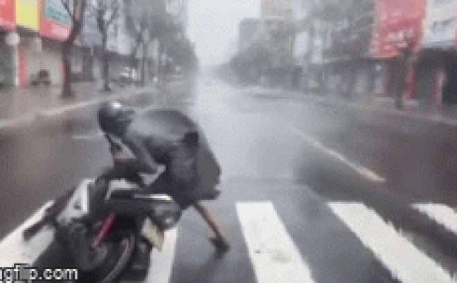 Camera giao thông: Gió bão quật như muốn hất tung người, thanh niên vật vã kéo xe vào lề đường tránh trú