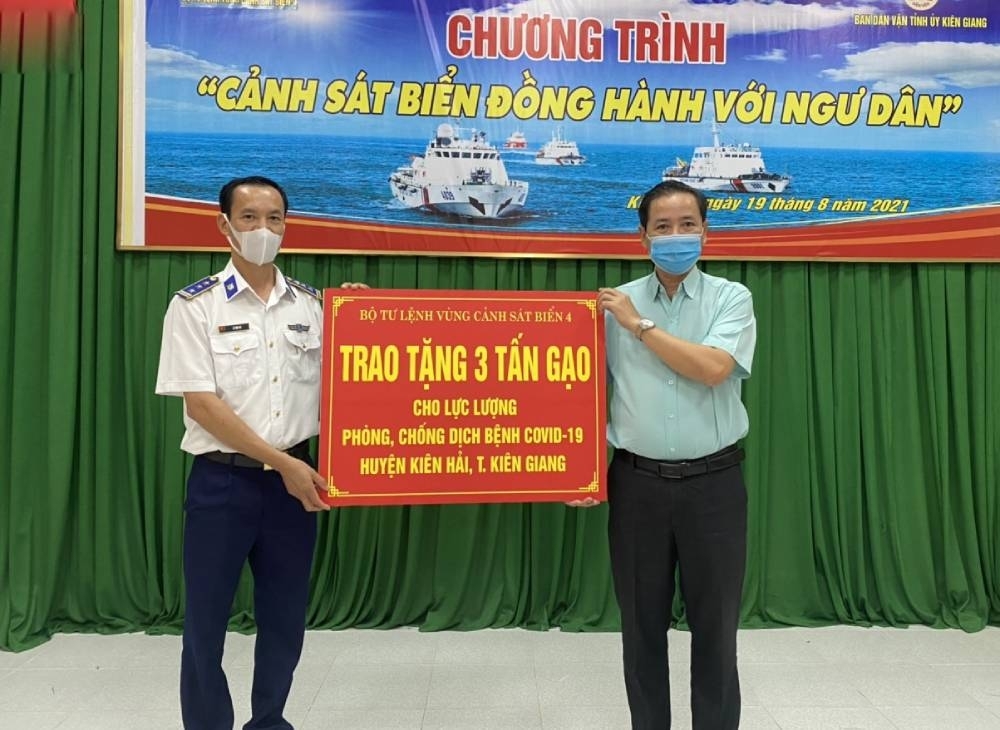 Thượng tá Lê Văn Tú - Phó Chính ủy BTL Vùng Cảnh sát biển 4 trao quà hỗ trợ các gia đình có hoàn cảnh khó khăn và lực lượng làm nhiệm vụ phòng, chống dịch COVID-19 cho đại diện chính quyền địa phương xã đảo Hòn Tre.