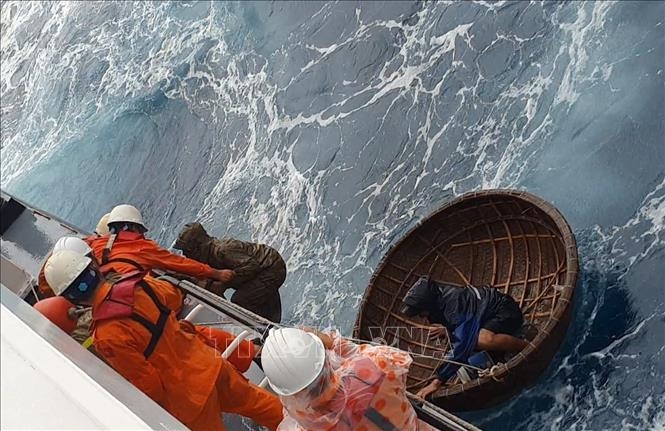 Hai thuyền viên được tìm thấy trên biển và được cứu lên tàu SAR 412. Ảnh: TTXVN phát