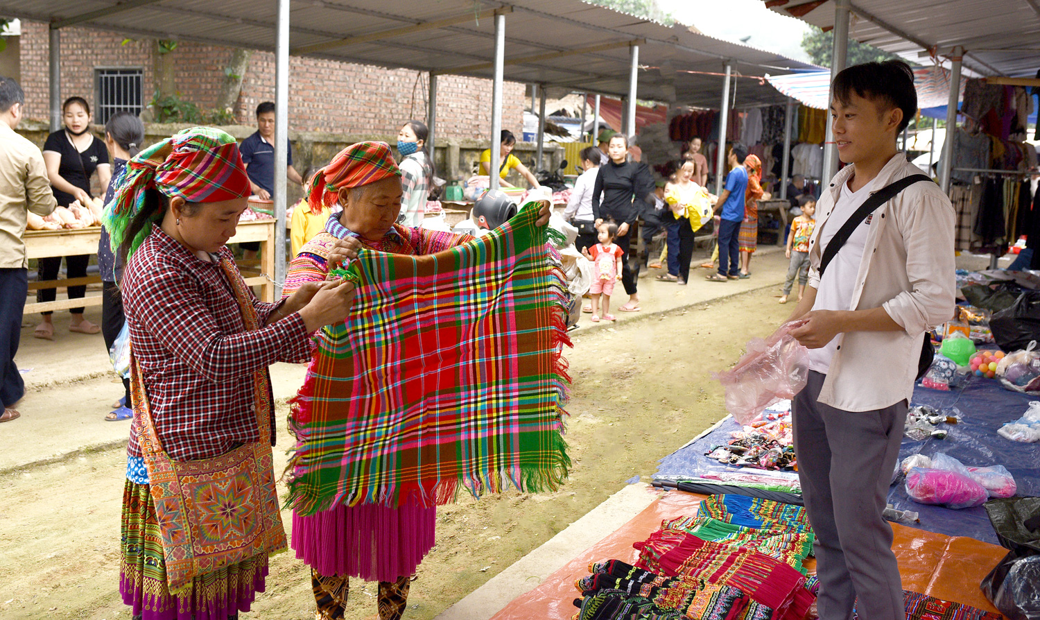 Hai người Mông đang trả giá một chiếc khăn thổ cẩm, đây là chiếc khăn mà người phụ nữ Mông thường đội đầu.