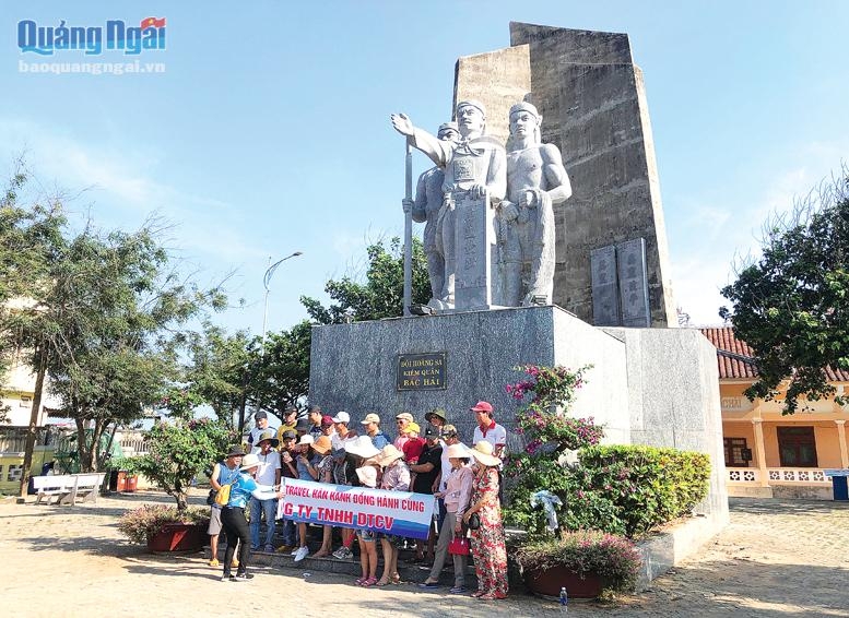 Du khách chụp hình kỷ niệm trước tượng đài Đội Hoàng Sa kiêm quản Bắc Hải. ẢNH: XUÂN THIÊN