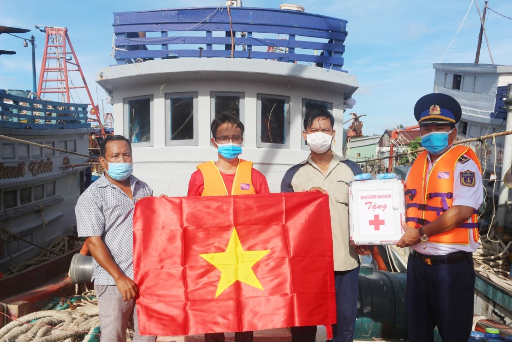 BTL Vùng Cảnh sát biển 4 tặng cờ Tổ quốc và tủ thuốc cho ngư dân huyện Hòn Đất (Kiên Giang). Ảnh: Văn Quốc