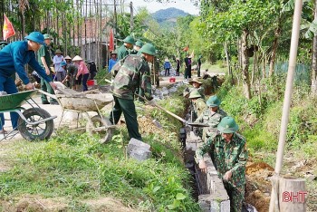 Bộ đội biên phòng hỗ trợ người dân biên giới đắp lề, đổ bê tông mở rộng đường