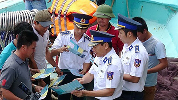 Cảnh sát biển Vùng 3 phát tờ rơi tuyên truyền cho ngư dân Vũng Tàu đánh bắt hải sản đúng hải phận - Ảnh: Đ.HÀ