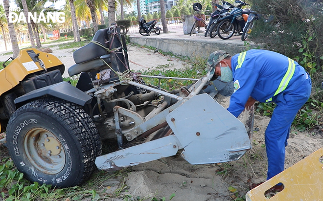 Anh Nguyễn Văn Tình, công nhân Xí nghiệp Môi trường sông biển đang vệ sinh máy sàng cát sau. Ảnh: VĂN HOÀNG