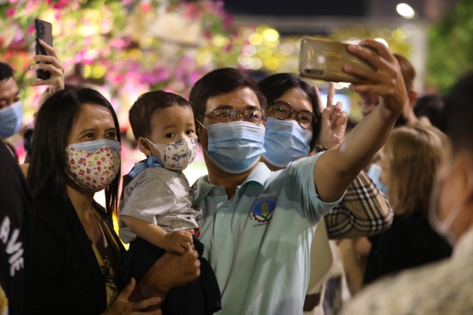 Một gia đình chụp hình lưu niệm trong đêm giao thừa tại đường hoa Nguyễn Huệ. Ảnh: Quỳnh Trần/vnexpress.net