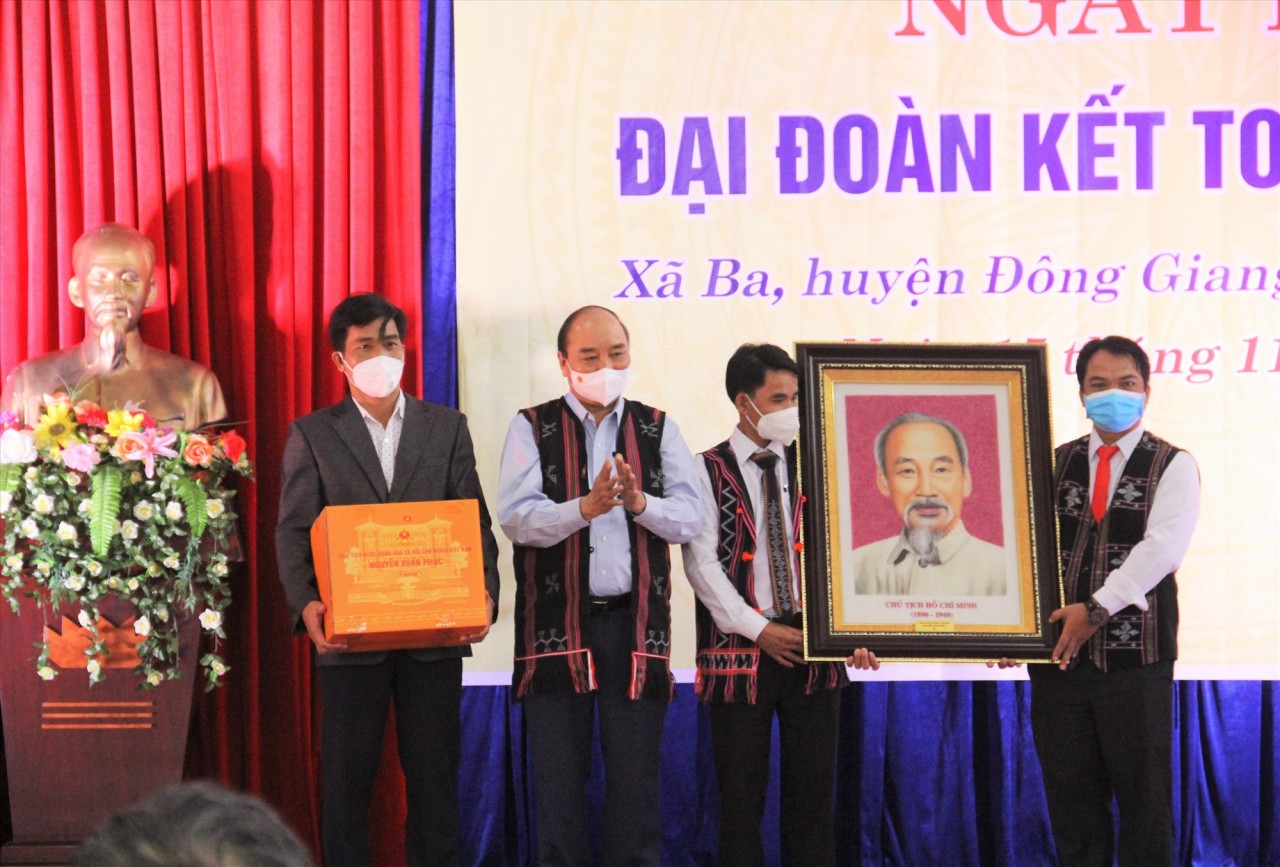 Thay mặt đoàn công tác, Chủ tịch nước Nguyễn Xuân Phúc trao tặng chân dung Chủ tịch Hồ Chí Minh cho Đảng bộ, chính quyền xã Ba. Ảnh: N.V/Báo Quảng Nam
