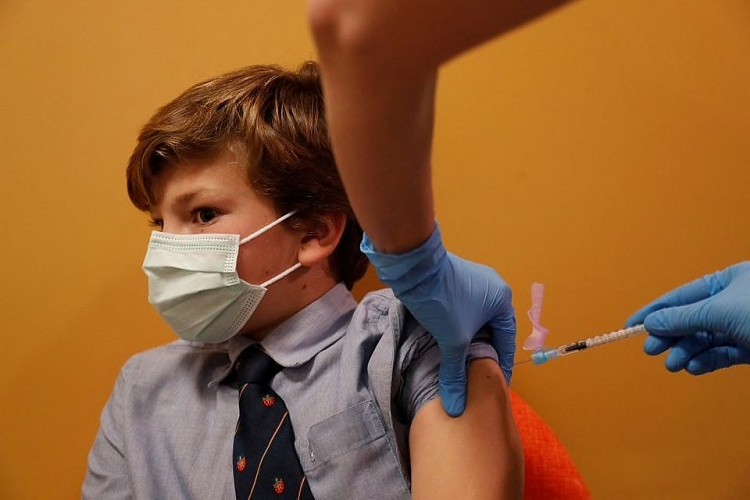 Pablo Peiro, 9 tuổi, phản ứng khi tiêm vaccine COVID-19 ở ngoại ô Madrid. Ảnh: Reuters