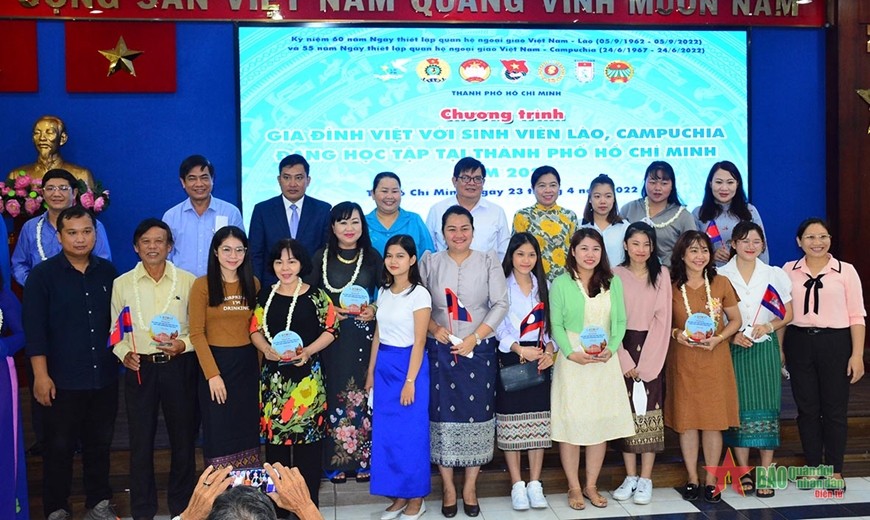  Các đại biểu chúc mừng những gia đình Việt đã nhận nuôi sinh viên Lào, Campuchia. (Ảnh: Báo Quân đội nhân dân)