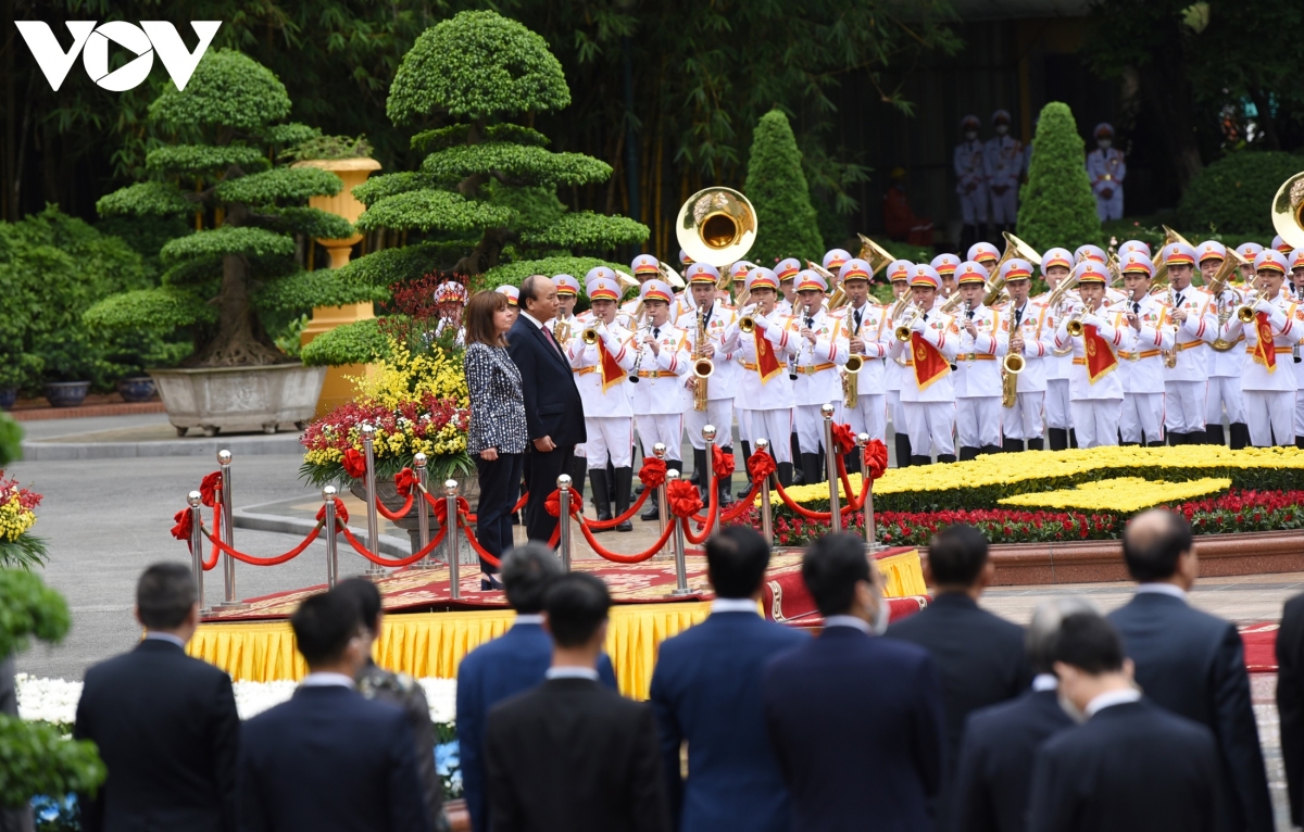 Chủ tịch nước Nguyễn Xuân Phúc và Tổng thống Hy Lạp Katerina Sakellaropoulou trên bục danh dự. Quân nhạc cử quốc thiều hai nước. Đoàn đại biểu cấp cao tháp tùng Tổng thống Hy Lạp gồm: Thứ trưởng Bộ Ngoại giao Andreas Katsaniotis; Đại sứ Đặc mệnh toàn quyền Hy Lạp tại Việt Nam Georgios Stylianopoulos; Đại sứ Athanasios Ioannou, Cục trưởng Cục châu Á và Đại dương, Bộ Ngoại giao Hy Lạp; Đại sứ Maria Solomou, Vụ trưởng Vụ Đối ngoại, Văn phòng Tổng thống; ông Ilias Natsios, Vụ trưởng Văn phòng riêng của Tổng thống; ông Ioannis Sarantopoulos, Thiếu tướng, Tư lệnh Cảnh vệ; ông Christodoulos Margartis, Tham tán đại sứ quán, Vụ trưởng Văn phòng Thứ trưởng ngoại giao; ông Dimitrios Papadimitriou, Trung tá, sĩ quan phụ tá của Tổng thống.