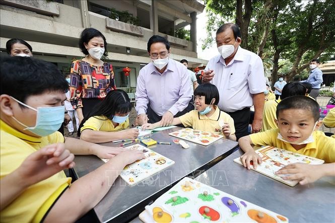 Thủ tướng Phạm Minh Chính thăm trẻ em được chăm sóc tại Trung tâm Bảo trợ trẻ em tàn tật tại Thị Nghè. Ảnh: TTXVN