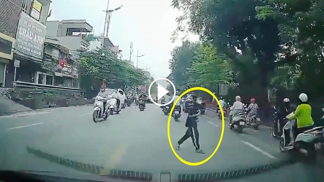 Cậu bé vòng tay, cúi đầu cảm ơn khi được tài xế nhường đường
