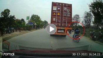 Thanh niên đi xe máy thản nhiên bám tay vào container để “đi nhờ”