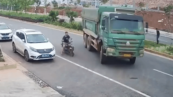 Camera giao thông: Chạy vào điểm mù, tài xế điều khiển xe máy chui lọt gầm xe tải