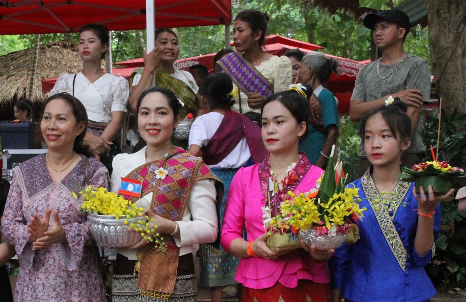 Những cô gái Lào ở Buôn Đôn mang trang phục truyền thống, cài hoa chăm pa di dự lễ hội