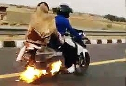 Người đàn ông chở vợ con trên chiếc xe máy bốc cháy