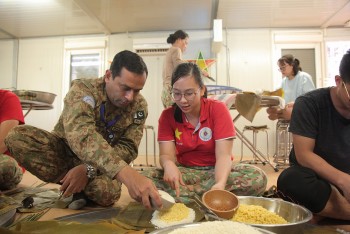 Chiến sĩ gìn giữ hòa bình hướng dẫn bạn bè quốc tế gói bánh chưng Việt Nam