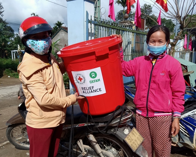 (Ảnh: Người dân tại huyện Bắc Trà My, Quảng Nam nhận bộ dụng cụ vệ sinh)