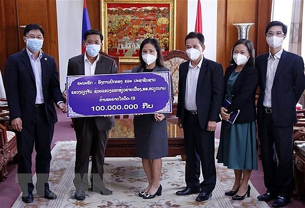Ông Thongsavan Vongsamphan, Phó Bí thư, Tỉnh trưởng tỉnh Vientiane (bên trái) trao tượng trưng số tiền hỗ trợ tỉnh Hải Dương phòng chống dịch COVID-19. (Ảnh: Phạm Kiên/TTXVN)