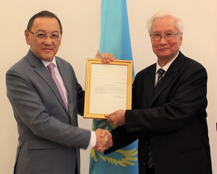 Đại sứ Đặc mệnh toàn quyền của Cộng hòa Kazakhstan tại Việt Nam Yerlan Baizhanov (bên trái) trao tặng Thư Cảm ơn của Tổng thống Kassym-Jomart Tokayev đến ông Đoàn Danh Nghiệp.