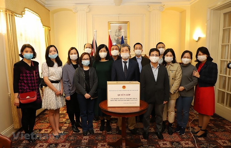 Cán bộ, nhân viên Đại sứ quán Việt Nam tại Anh và các cơ quan đại diện tham gia quyên góp ủng hộ đồng bào miền Trung. (Ảnh: TTXVN)