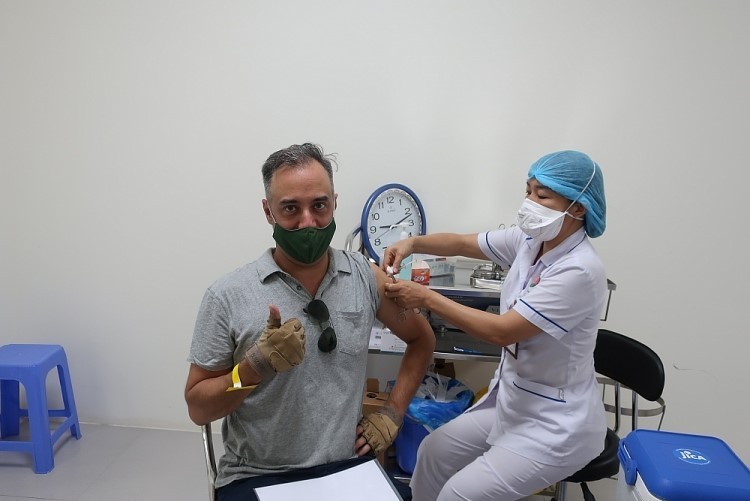 Nhân viên y tế tại Bệnh viện Phổi Trung ương tiêm phòng cho một cán bộ tổ chức PCPNN.