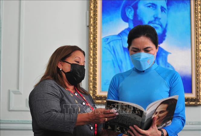 Bà Teresa Amarelle Boué trao tặng đồng chí Hà Thị Nga cuốn sách về truyền thống Hội Liên hiệp Phụ nữ Cuba. Ảnh: Vũ Hà/TTXVN