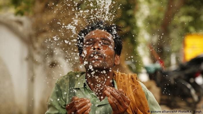 Người dân dùng nước để hạ nhiệt trong mùa nắng nóng. Ảnh: AP