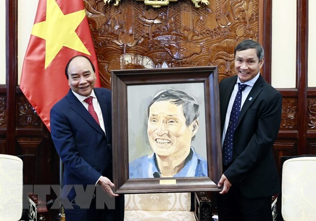 Chủ tịch nước Nguyễn Xuân Phúc tặng quà lưu niệm cho huấn luyện viên Mai Đức Chung. Ảnh: Thống Nhất/TTXVN