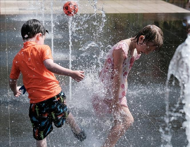 Trẻ em chơi dưới đài phun nước nhằm làm dịu nắng nóng ở Nice, miền Nam Pháp ngày 17/6/2022. Ảnh: THX/TTXVN
