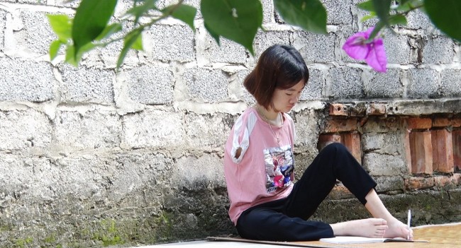 Những nét chữ được viết từ đôi chân của cô gái không có hai tay