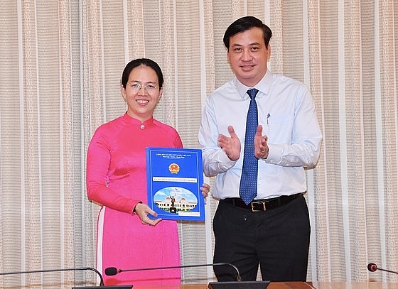 Phó Chủ tịch UBND TP.HCM Lê Hòa Bình trao quyết định cho bà Nguyễn Thị Bé Ngoan (Ảnh: VIỆT DŨNG/SGGP)
