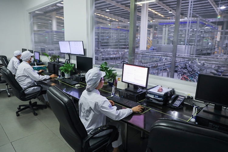 Các nhân viên tại nhà máy Vinamilk ở Bình Dương đang vận hành dây chuyền sản xuất sữa hiện đại hoàn toàn tự động hóa qua hệ thống máy tính
