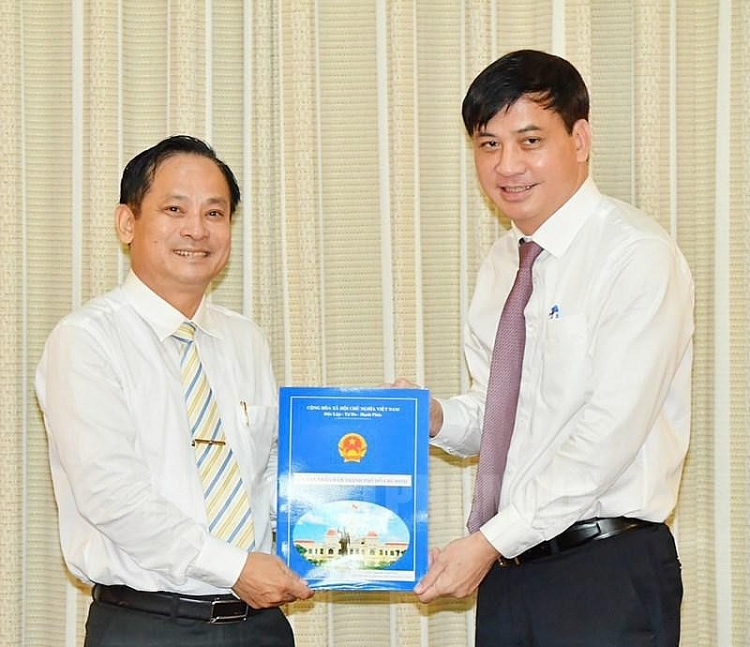 Ông Phạm Văn Lũy (trái) nhận quyết định (Ảnh: SGGP)