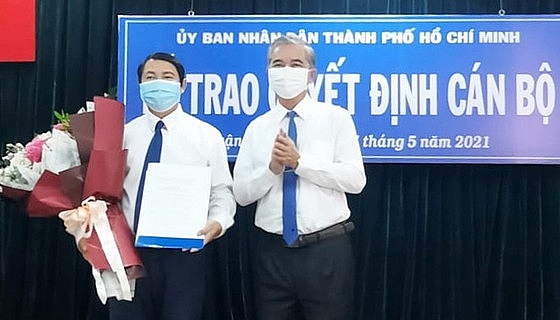 Phó Chủ tịch UBND TP.HCM Ngô Minh Châu (phải) trao quyết định cho ông Nguyễn Trí Dũng (Ảnh: HOÀI NAM/SGGP)