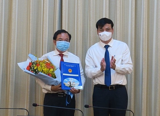 Phó Chủ tịch UBND TP.HCM Lê Hòa Bình (phải) trao quyết định điều động, bổ nhiệm ông Lê Quốc Tuấn (Ảnh: M.H/SGGP)