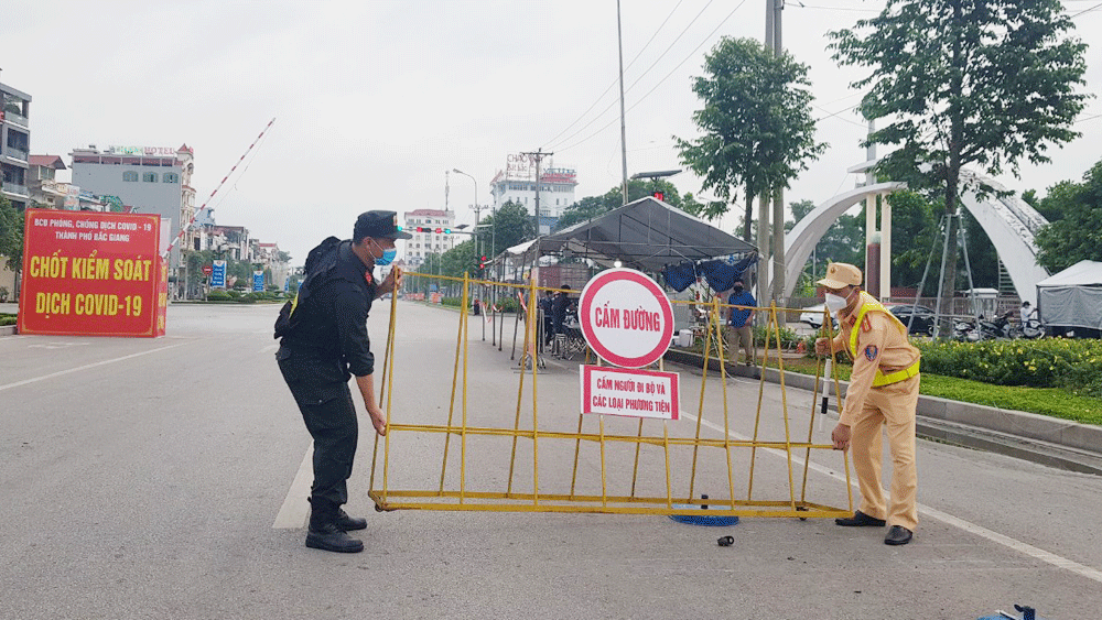 Lực lượng chức năng dỡ chốt kiểm soát dịch tại đường Hùng Vương (Ảnh: Báo Bắc Giang)