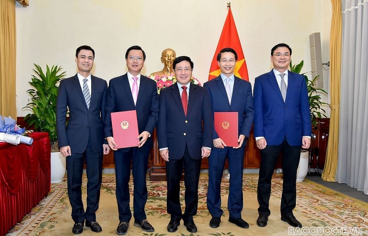 Phó Thủ tướng, Bộ trưởng Bộ Ngoại giao Phạm Bình Minh trao quyết định cho 2 cán bộ (Ảnh: VGP)