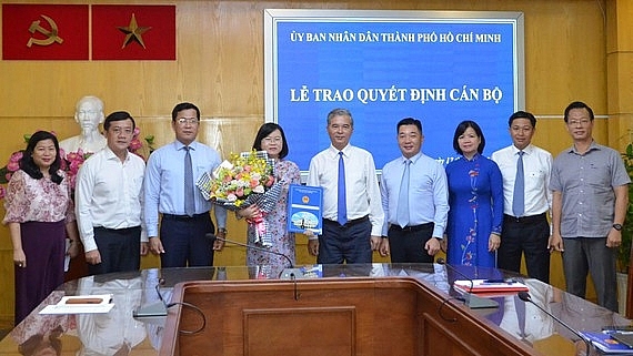 Phó Chủ tịch UBND TP.HCM Ngô Minh Châu trao quyết định cho bà Võ Thị Chính (Ảnh: HOÀI NAM/SGGP)