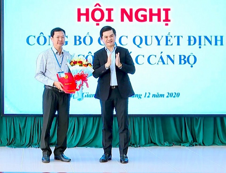 Ông Vũ Chí Hùng (phải), Phó tổng Cục trưởng Tổng cục Thuế, trao quyết định và hoa chúc mừng ông Nguyễn Thanh Bình (Ảnh: Báo Hậu Giang)