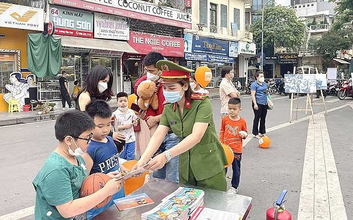 Công an quận Hoàn Kiếm (Hà Nội) phát tờ rơi tuyên truyền kiến thức về phòng cháy, chữa cháy cho trẻ em và du khách tại phố đi bộ. (Ảnh Cơ quan công an cung cấp)