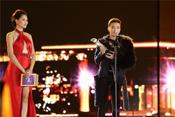 chan dung nam ca si phia sau mot co gai dang duoc gioi tre ham mo