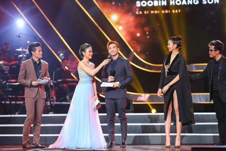 chan dung nam ca si phia sau mot co gai dang duoc gioi tre ham mo