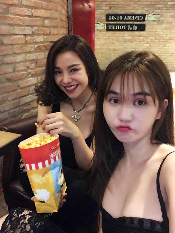 ngoc trinh vo tu cuoi dua gac chan len ghe noi cong cong