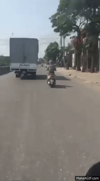 nguoi phu nu di xe may chay song song xe tai hon 10km chi de tranh nang