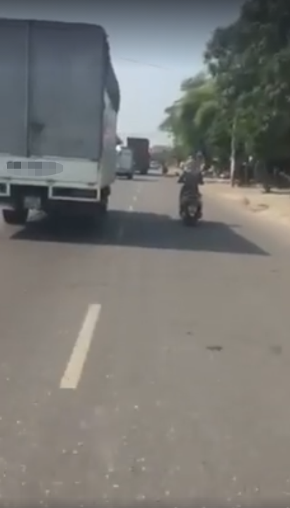 nguoi phu nu di xe may chay song song xe tai hon 10km chi de tranh nang