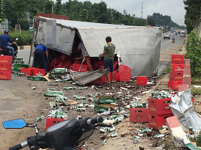 binh duong xe tai cay nat thanh cau roi lat ngang duong nguoi dan den thu gom bia giup tai xe