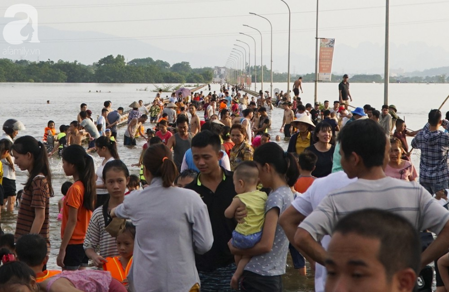 ha noi nguoi lon cung tre nho thich thu boi loi giua duong quoc lo thoi ngap lut