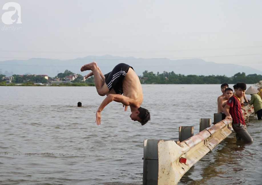 ha noi nguoi lon cung tre nho thich thu boi loi giua duong quoc lo thoi ngap lut