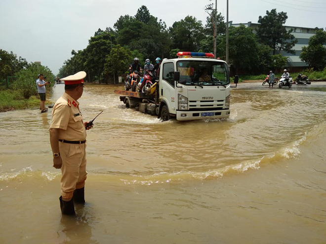 ha noi csgt dung xe chuyen dung giup dan di chuyen qua vung ngap ung